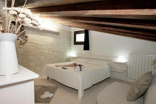 a white bedroom with a bed and a couch at Residence San Martino in Erice