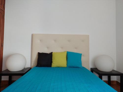 ein Schlafzimmer mit einem blauen Bett mit zwei weißen Helmen in der Unterkunft Alltravel Atlântico apartment in Portimão