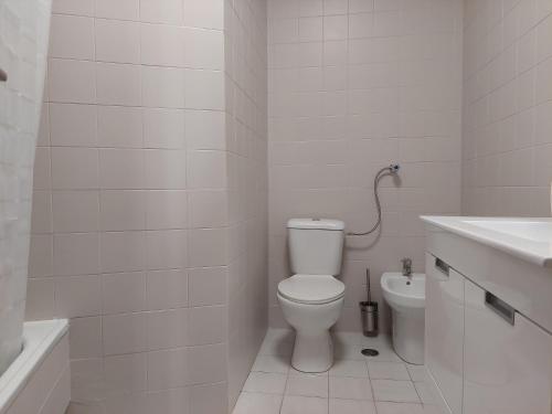 ein weißes Bad mit einem WC und einem Waschbecken in der Unterkunft Alltravel Atlântico apartment in Portimão