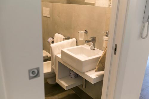 a bathroom with a white sink and a mirror at Via Del Faro Apartments in Torre Canne