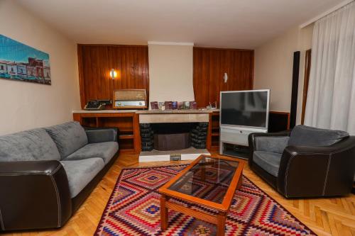 a living room with a couch and a tv at Hotel Kristal in Korçë