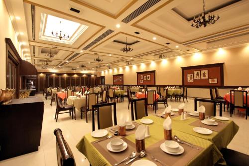 a restaurant with tables and chairs in a room at Taj Mahal Hotel Abids in Hyderabad