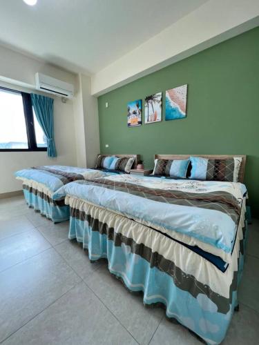 twee bedden in een kamer met groene muren bij Lo-ReMi Homestay in Ruisui