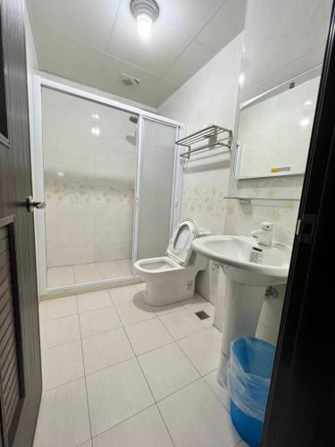 een badkamer met een toilet, een wastafel en een douche bij Lo-ReMi Homestay in Ruisui