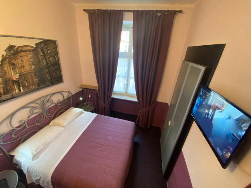 a bedroom with a bed and a flat screen tv at Artua'&Solferino in Turin