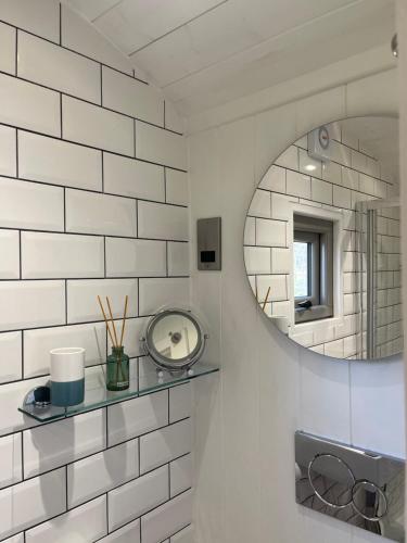 a bathroom with a mirror and a sink at Luxury Shepherds Hut - The Sweet Pea by the lake in York