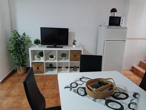 uma sala de estar com uma mesa e uma televisão em Apartamento Casa Quiles 