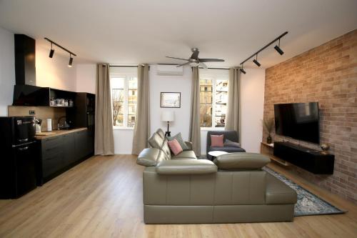 a living room with a couch and a brick wall at Apartments INCIS next to the Pula Amphitheather in Pula