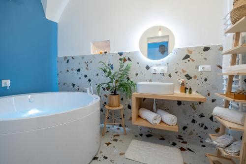 a bathroom with a tub and a sink at La Bella Ostuni Suites in Ostuni