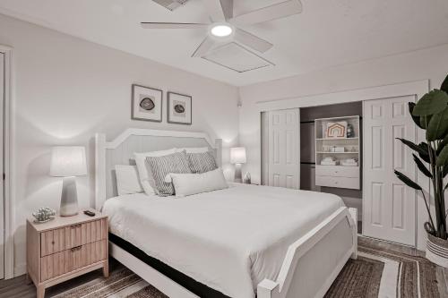 a white bedroom with a large bed and a ceiling fan at Sunrise Beach Retreat in Flagler Beach