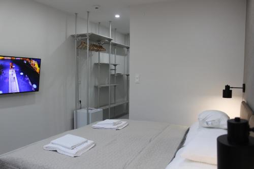 a bedroom with a bed with a tv on the wall at Szkíta Panzió in Balatonmáriafürdő