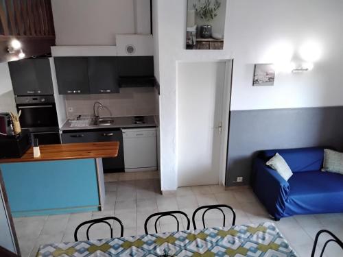 a small kitchen with a blue couch in a room at Strada di a cuma in Vico