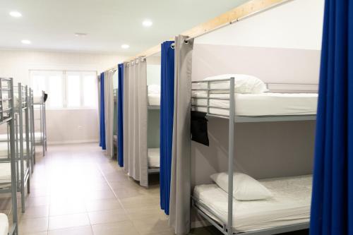 a row of bunk beds in a dorm room at Albergue Barullo - Cubículos - Literas - Habitaciones in Sarria