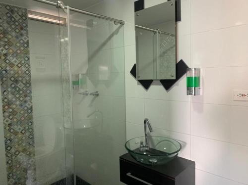a bathroom with a glass sink and a shower at HOTEL MC in Pasto