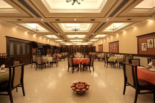 a dining room with tables and chairs and a ceiling at Taj Mahal Hotel Abids in Hyderabad