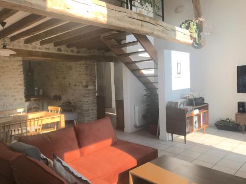 a living room with a couch and a table at Le Vallon du Perche in Champeaux-sur-Sarthe