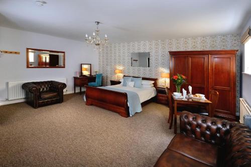 a hotel room with a bed and a chair at Beachside Suites in Minehead