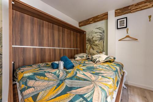 um quarto com uma cama grande e uma cabeceira em madeira em Chez Ingres - Le Nid - Joyau caché en centre ville em Montauban