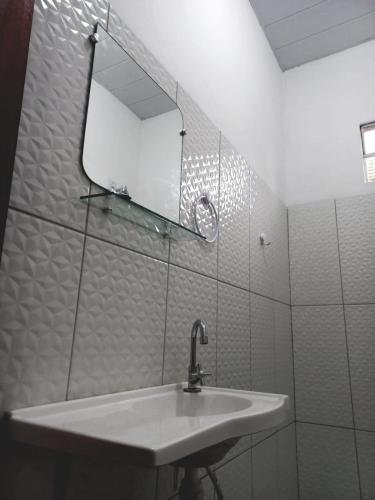 a white bathroom with a sink and a mirror at POUSADA DO BETO in Atins