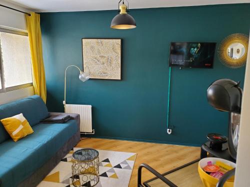 - un salon avec un canapé et un mur bleu dans l'établissement CHARMANT STUDIO☆NETFLIX☆CANAL+☆CANAL SAT☆PARKING☆, à Ramonville-Saint-Agne