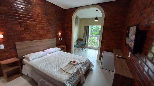 a bedroom with a bed and a brick wall at Pousada Casarão do Porto - Porto de Galinhas PE in Porto De Galinhas