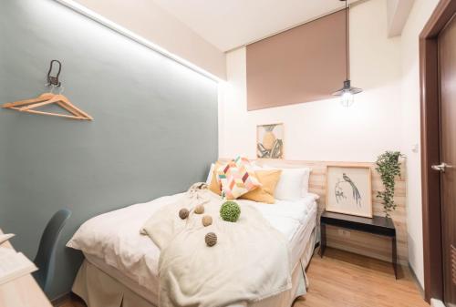 Cette petite chambre comprend un lit avec des draps blancs. dans l'établissement 在家行旅 中山館, à Taipei