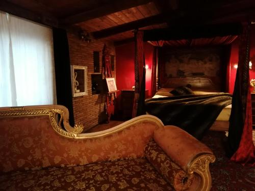 een woonkamer met een bank en een bed bij La stanza nel parco in Anguillara Sabazia