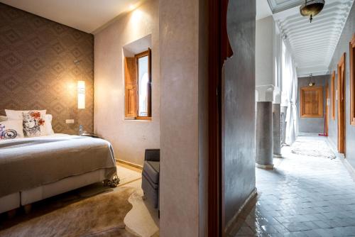a hotel room with a bed and a hallway at Riad Houma in Marrakech