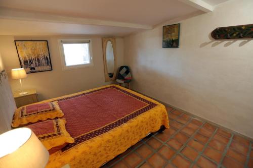 Schlafzimmer mit einem Bett und einem Fenster in der Unterkunft LUBERON DES ARTISTES 2 in Apt