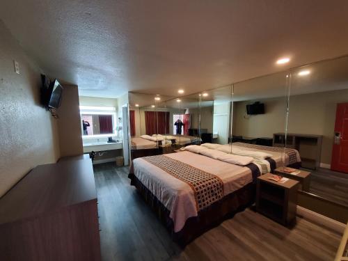 a hotel room with a large bed and a mirror at River Inn Motel in San Antonio