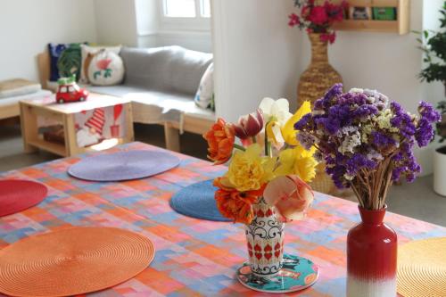 a table with a vase of flowers in a living room at Chambres d'hôtes "HOR DAGO" près de la gare d'Hendaye avec le petit-déjeuner in Hendaye