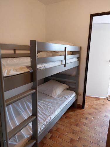 - 2 lits superposés dans une chambre avec un miroir dans l'établissement Saint Cyprien - Appart - Piscine-Mer, à Saint-Cyprien