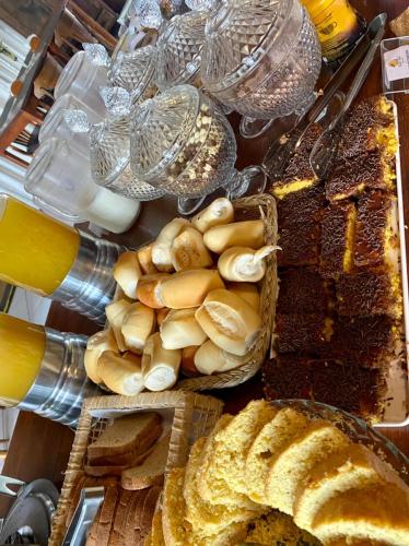 a table with various types of bread and pastries at WINNER BEACH HOTEL in Juréia