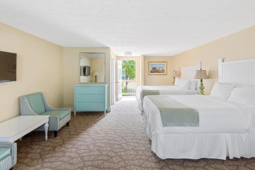 a hotel room with two beds and a chair at Colonial Inn in Ogunquit