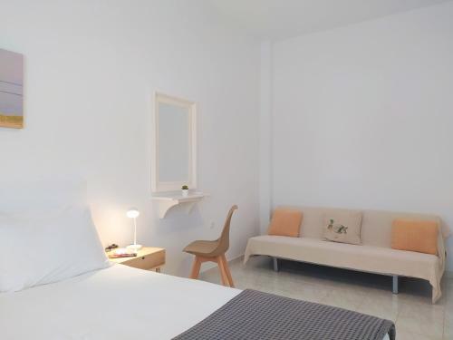 Cette chambre blanche dispose d'un lit et d'un canapé. dans l'établissement George's Place Sifnos - apartments, à Apollonia