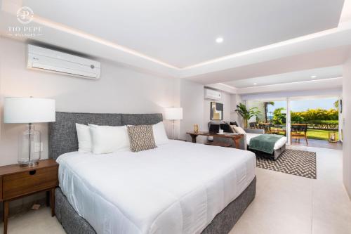 a bedroom with a white bed and a living room at Harbor Puerto Vallarta 1008 in Puerto Vallarta