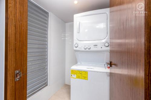a washer and dryer in a bathroom with a window at Harbor Puerto Vallarta 1008 in Puerto Vallarta