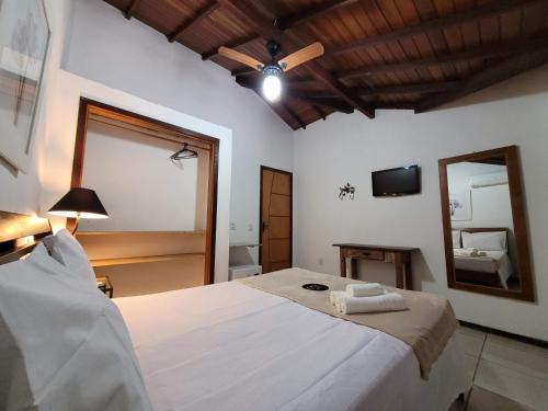 a bedroom with a large bed and a mirror at Centro Up! in Búzios