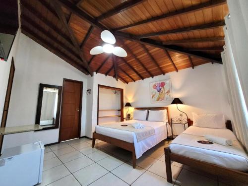 a bedroom with two beds and a wooden ceiling at Centro Up! in Búzios