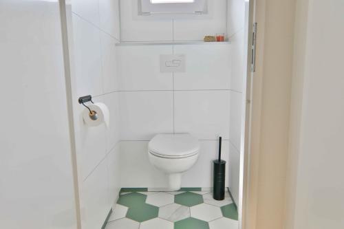 baño con aseo y suelo verde y blanco en Buitenlede 7 - Suite M, en Dwingeloo