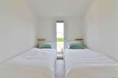 two beds in a room with a window at Buitenlede 7 - Suite M in Dwingeloo