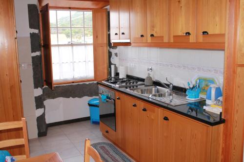 a kitchen with a sink and a stove at A Casa dos Meus Sonhos in Santo Amaro