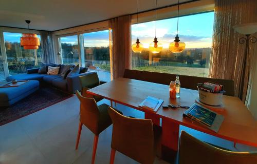 salon ze stołem, krzesłami i kanapą w obiekcie 360 Grad - the view w mieście Ilsfeld