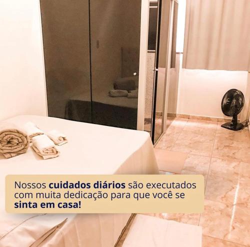 y baño con cama y ducha con espejo. en Hotel Havana en Nova Serrana