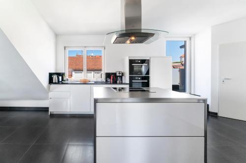 a kitchen with white cabinets and a stove at Ferienwohnung Riviera Self Check-in in Überlingen
