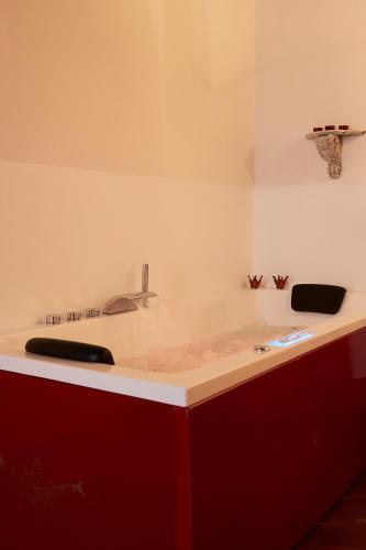 a kitchen counter with a sink and red cabinets at Castello del Capitano delle Artiglierie in Castrocaro Terme