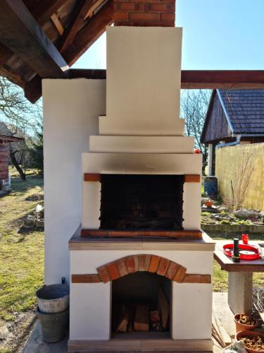 an outdoor pizza oven in a yard with a table at Penzión Larix Blatnica in Blatnica