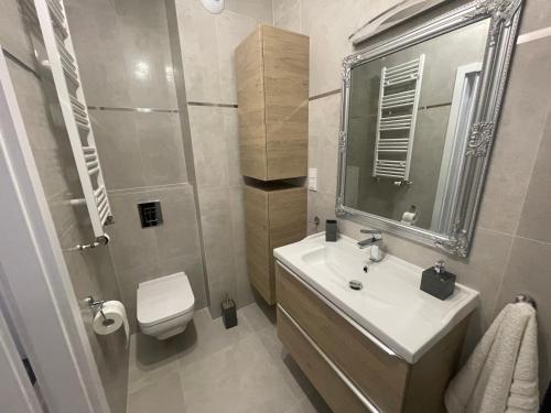 biała łazienka z umywalką i toaletą w obiekcie Apartament Luna Baltic Marina Residence w Kołobrzegu