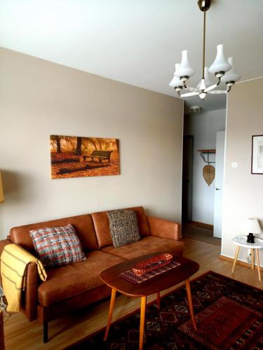 a living room with a brown couch and a table at Citykoti in Varkaus