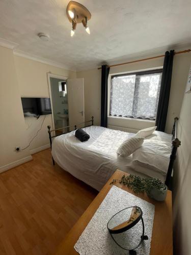 a bedroom with a bed and a table and a window at 6 Bedroom House For Corporate Stays in Corby Suitable for Nightshift Workers in Great Oakley